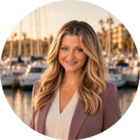 Professional headshot of Stacey Schramm, Marketing Director at SVN Marinas, standing in front of a marina with boats at sunset