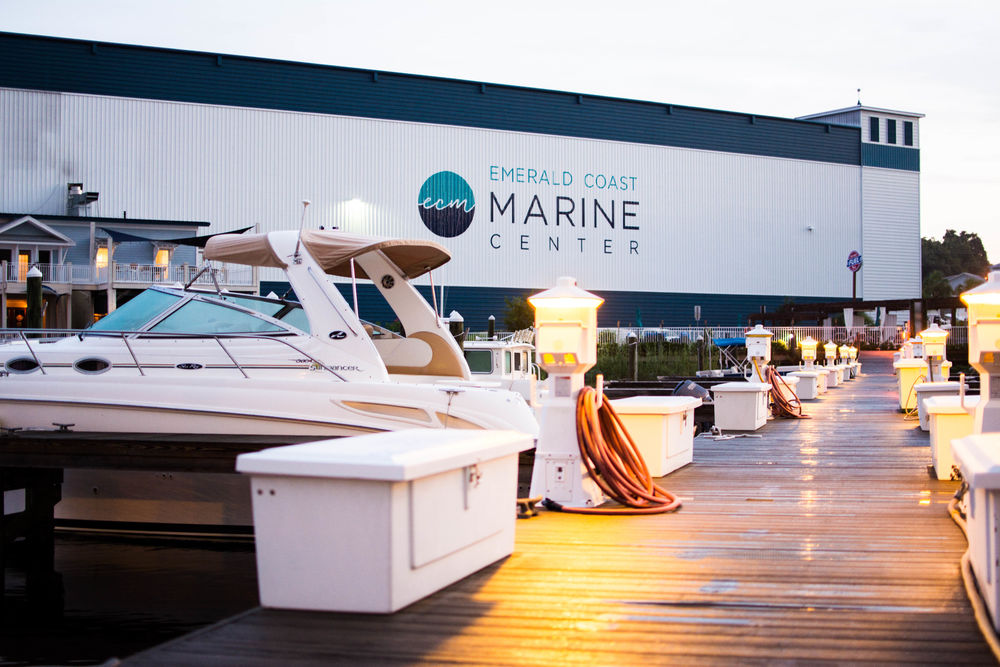 Motor yacht docked outside Emerald Coast Marine Center in Niceville, Florida, beside an illuminated marina walkway.